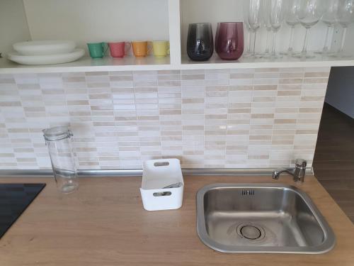 eine Küchentheke mit einer Spüle und einer Arbeitsplatte mit Geschirr in der Unterkunft GIANGY HOME in Casteldaccia
