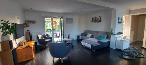 - un salon avec un canapé, une chaise et une table dans l'établissement Maison cosy à Saint-Méloir-des-Ondes avec jardin privé, à Saint-Méloir-des-Ondes