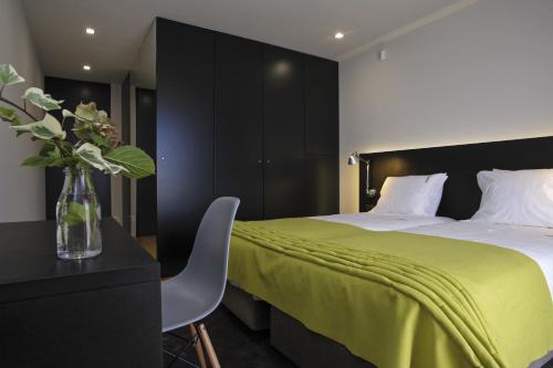 a bedroom with a bed and a vase of flowers at Casa de l Cura in Miranda do Douro