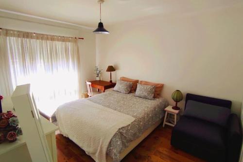 1 dormitorio con 1 cama, 1 silla y 1 ventana en DockApartment, en Vila Nova de Gaia