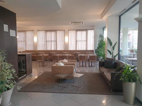 a living room with a couch and a tables and chairs at Hotel Bianca Vela in Rimini