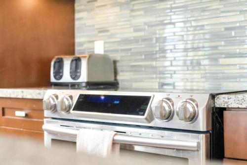 a stove top oven with a toaster on top of it at Lakeview Splendor- 7BR Penthouse Bliss Combo unit in Harrison Hot Springs