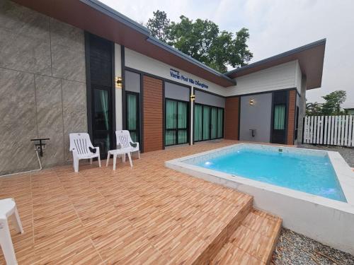 une terrasse avec une piscine et des chaises ainsi qu'une maison dans l'établissement Vamin Poolvilla Chiangkhan Loei วามินทร์พูลวิลล่า เชียงคาน เลย - วามินทร์ รีสอร์ท, à Chiang Khan
