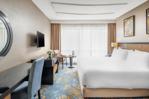 a hotel room with a large bed and a desk at Al Ghufran Safwah Hotel Makkah in Makkah