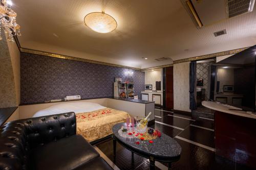 a bedroom with a bed and a table and a couch at Happy Kiss (Adult Only) in Showa