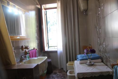 baño con lavabo y aseo y ventana en Casa de Rosa, en Vietri