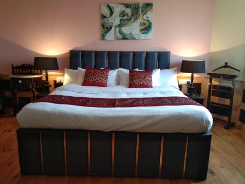 a large bed with red pillows in a bedroom at Naldehra House in Shimla
