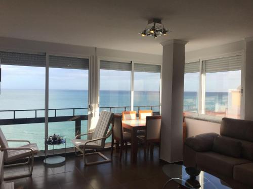a living room with a table and chairs and the ocean at Stunning views to the sea / City center Fuengirola in Fuengirola