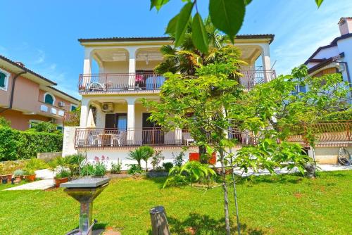 uma casa grande com um jardim em frente em Ferienwohnung für 3 Personen ca 32 qm in Poreč, Istrien Istrische Riviera em Porec