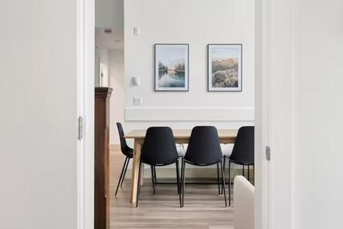 a dining room with a table and black chairs at Lakeview Splendor- 7BR Penthouse Bliss Combo unit in Harrison Hot Springs