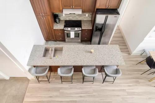 a kitchen with a counter with chairs around it at Lakeview Splendor- 7BR Penthouse Bliss Combo unit in Harrison Hot Springs