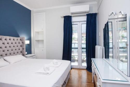 Un dormitorio con una gran cama blanca y una ventana en Brand new apt in Zografou, en Atenas