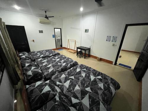 um quarto com uma cama com um edredão preto e branco em Errol's Homestay and Hostel em Siem Reap