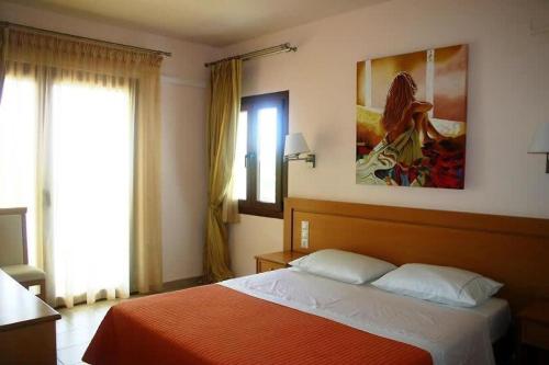 1 dormitorio con 1 cama y una pintura en la pared en Luxury Villa Nefeli w Private Pool In Skiathos en Troulos