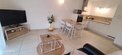 un salon avec une télévision et une cuisine dans l'établissement Appartement T2 centre ville Île Rousse, à LʼÎle-Rousse