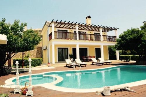 a villa with a swimming pool in front of a house at Dreamy Villa Jasmine with Private Pool In Skiathos in Troulos