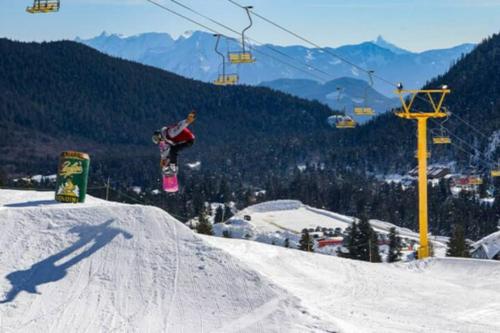 a person on a snowboard jumping off of a snow ramp at Lakeview Splendor- 7BR Penthouse Bliss Combo unit in Harrison Hot Springs