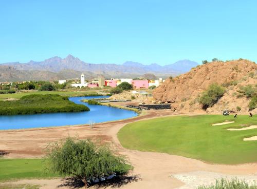a golf course with a river and mountains in the background at Loreto Bay Golf & Sea at Baja in Loreto