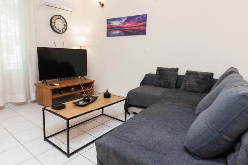 uma sala de estar com um sofá e uma televisão em Delightful Modern 1 Bedroom Apartment in Kallithea em Atenas