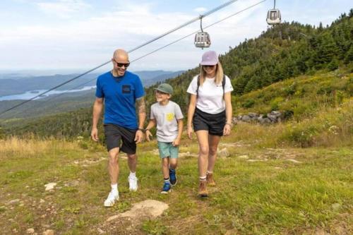 a man and a woman and a child walking on a mountain at Lakeview Splendor- 7BR Penthouse Bliss Combo unit in Harrison Hot Springs