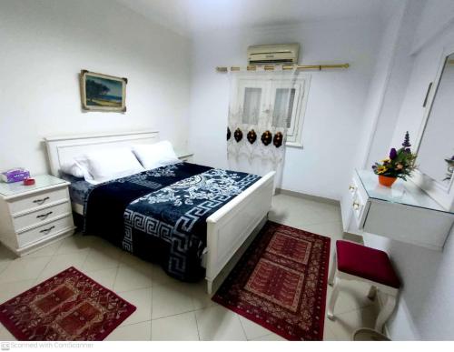 een slaapkamer met een bed, een dressoir en een raam bij ابراج المهندسين المعادي كورنيش بجوار مستشفي السلام الدولي in Caïro
