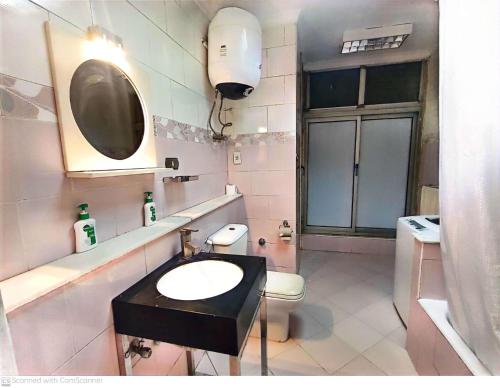 een badkamer met een wastafel, een toilet en een spiegel bij ابراج المهندسين المعادي كورنيش بجوار مستشفي السلام الدولي in Caïro