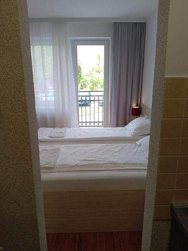 a bedroom with a bed and a window at Apartment Atina in Subotica