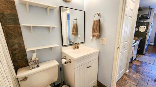 a bathroom with a toilet and a sink and a mirror at 1 BDR Condo in the Heart of Breck Walk to Gondola in Breckenridge