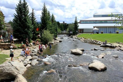 a group of people playing in a river with rocks at 1 BDR Condo in the Heart of Breck Walk to Gondola in Breckenridge