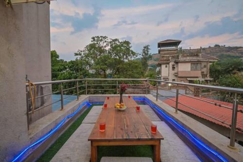 a wooden table on the balcony of a building at RK Villa in Lonavala