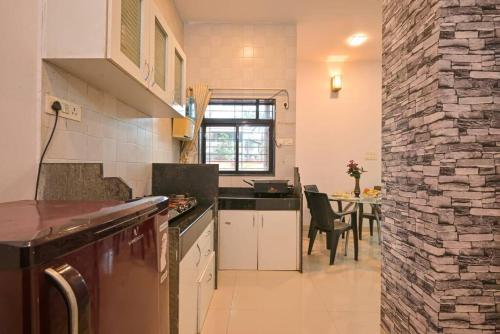 a kitchen with a counter and a table with chairs at RK Villa in Lonavala