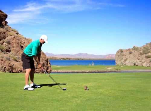 a man is playing golf on a golf course at Loreto Bay Golf & Sea at Baja in Loreto