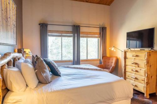 1 dormitorio con 1 cama, TV y ventana en Rocky Mountain Mama, en Breckenridge