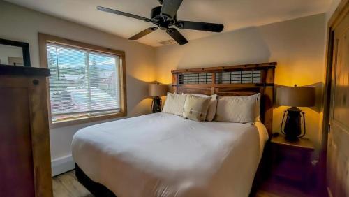 a bedroom with a large bed with a ceiling fan at Cozy Val dIsere Chalet Steps into Town in Breckenridge