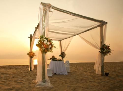a tent on the beach with a table and flowers at Loreto Bay Golf & Sea at Baja in Loreto