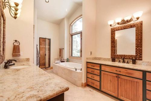a bathroom with a tub and a sink and a mirror at Lazy Fox Lodge in National Forest View in Breckenridge