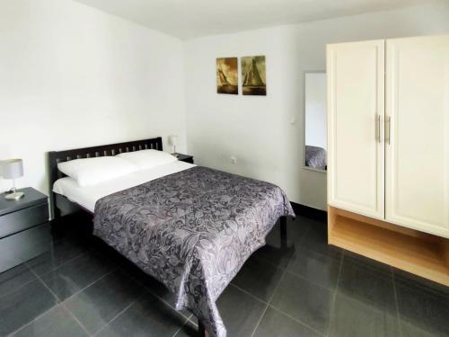 a bedroom with a bed and a white cabinet at Rafael Apartments in Medulin