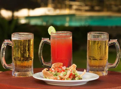 two glasses of beer and a plate of food on a table at Loreto Bay Golf & Sea at Baja in Loreto