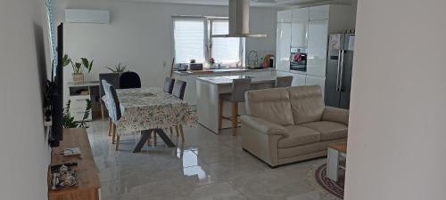 a kitchen and living room with a table and a couch at Private Zimmer Wohnung Braunau in Dietraching