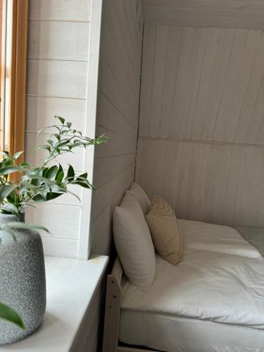 a small bed in a room with a potted plant at Mätta puhketalu in Tori