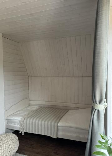 a white bed in a room with a curtain at Mätta puhketalu in Tori