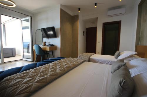 a hotel room with two beds and a television at ARXONTIKO in Himare