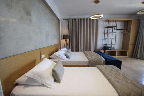 a hotel room with two beds and a couch at ARXONTIKO in Himare