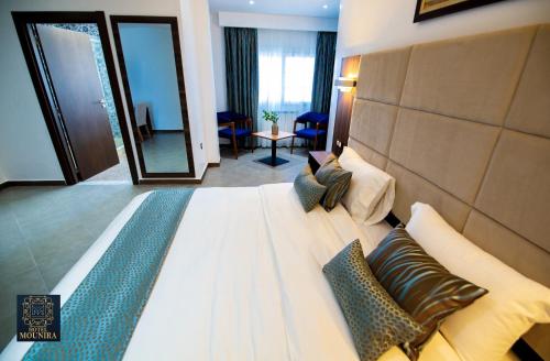 een hotelkamer met een groot bed met kussens bij HOTEL MOUNIRA in Arzew