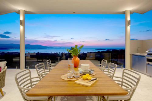 a dining room table with a view of the ocean at Sunset Estates - Samui Luxury Villas in Choeng Mon Beach