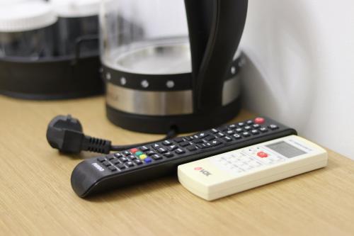 a remote control sitting on a table next to a coffee mug at ARXONTIKO in Himare