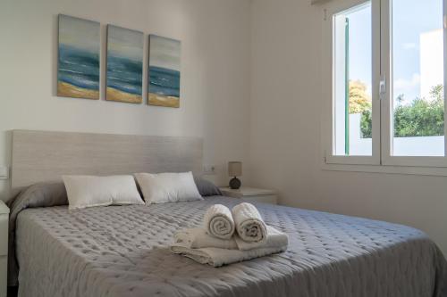 a bedroom with a bed with towels on it at Apartamento Villa Irene Menorca in Cala Santandria