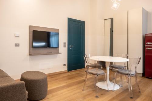 a living room with a table and chairs and a tv at EVE Home Collection - City Center in Trieste