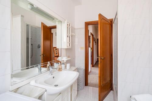 a white bathroom with a sink and a tub at Casa Brando in Santa Maria delle Mole