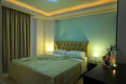 a bedroom with a bed with two lamps and a table at Panorama Inn Hotel in Paralia Katerinis